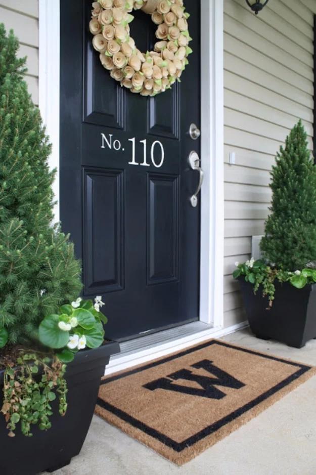 DIY curb appeal monogrammed coir welcome mat with a painted black border and letter at a black front door with planters