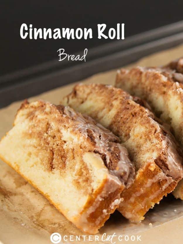 Cinnamon roll bread sliced on a dark background showing cinnamon streusel swirls through the pale crumb