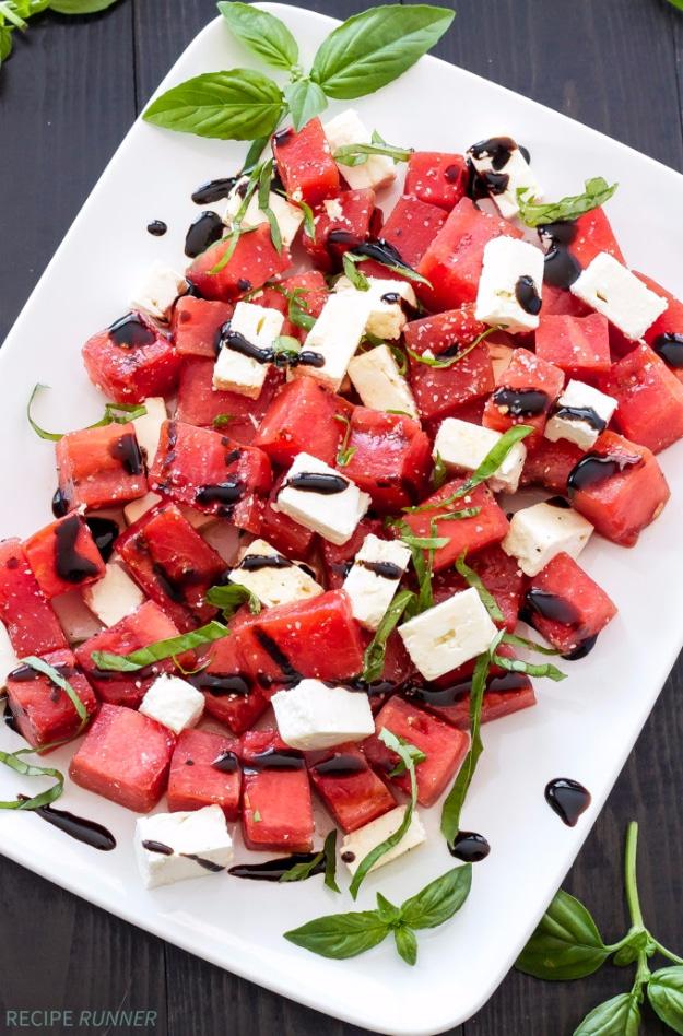 Grilled watermelon salad cut in cubes with feta, torn basil and a balsamic glaze drizzle at a summer cookout