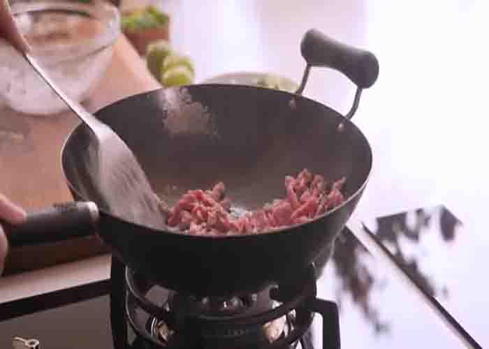 Stir-frying the steak stirps for the chili beef noodles