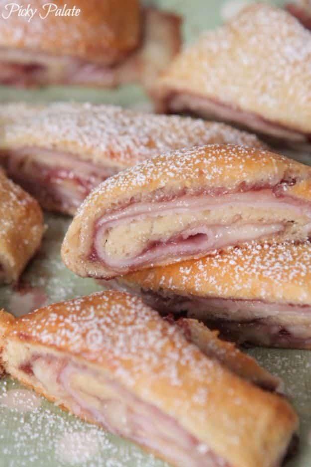 Monte Cristo crescent roll ups with turkey, provolone and berry jam, sliced and dusted with powdered sugar