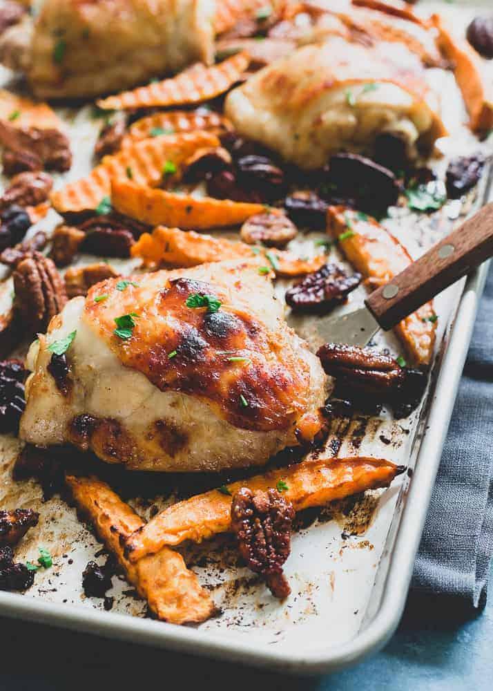 Sheet pan chicken thighs with sweet potato wedges and pecan halves in a maple dijon glaze, roasted golden