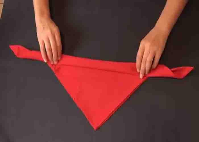 Rolling the cloth napkin to turn it into rose