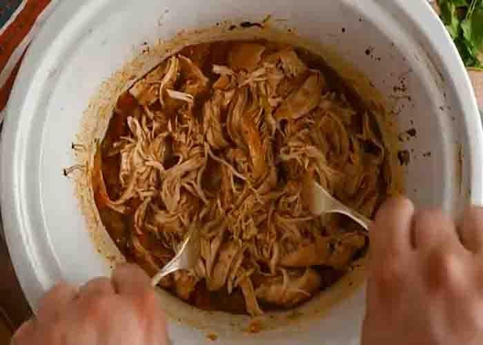 Shredding the chicken to make the tacos