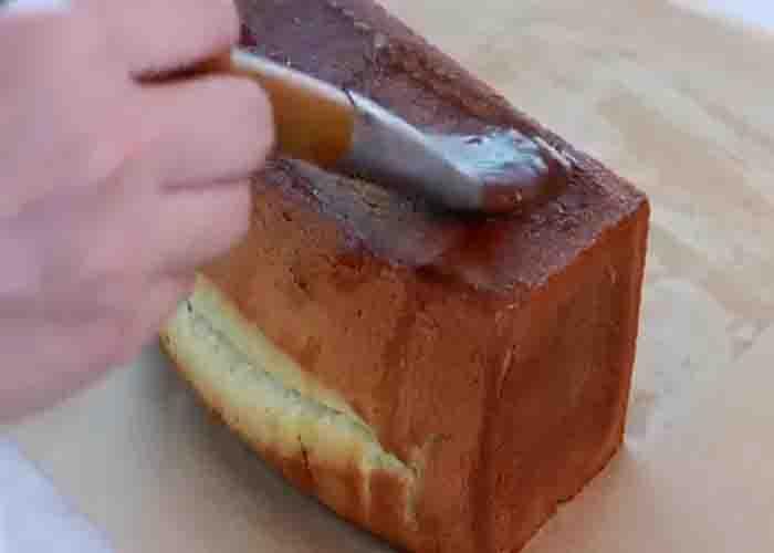 Brushing the lemon syrup on the lemon pound cake