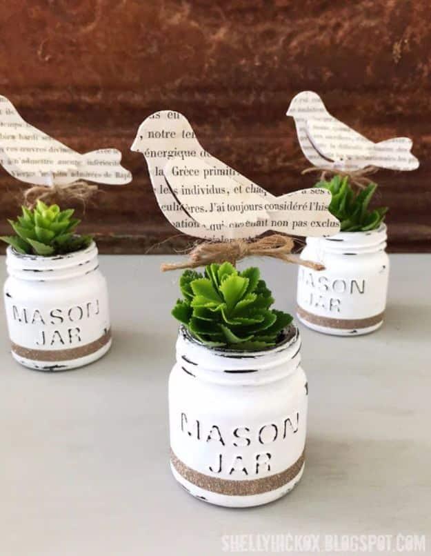 Three little painted mason jar planters lined up on a windowsill with small succulents, a rustic craft to sell