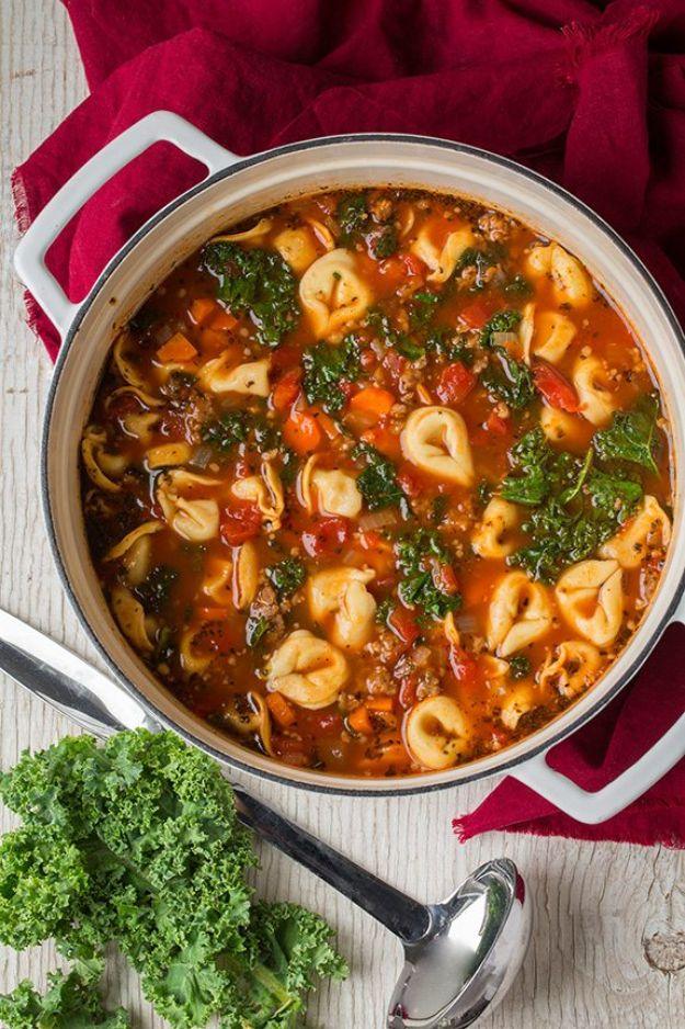 Italian sausage, kale and tortellini soup in a large red pot with tortellini and greens in tomato broth