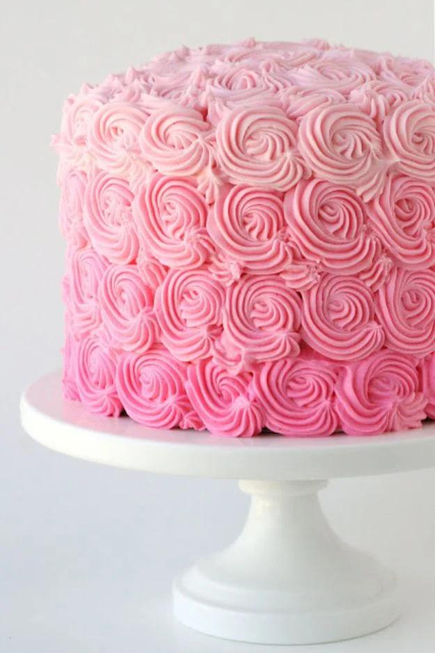 Pink ombre baby shower cake covered in piped rosettes shading from deep pink at the base to pale pink on top