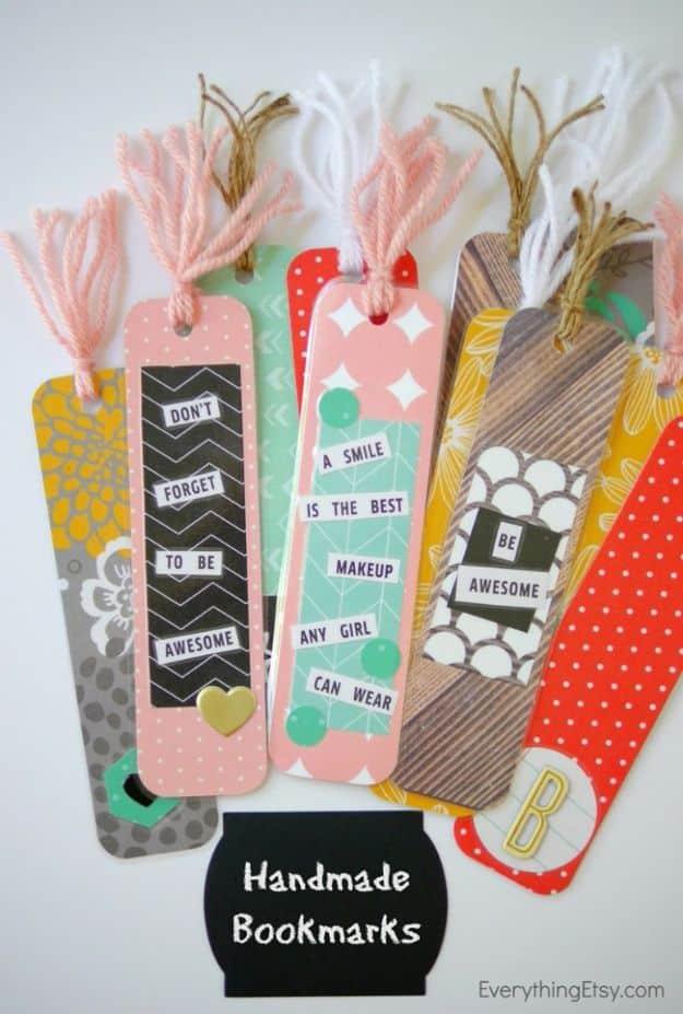 Five patterned paper bookmarks in pink, gray and orange with printed phrases and pale yarn tassels, fanned out