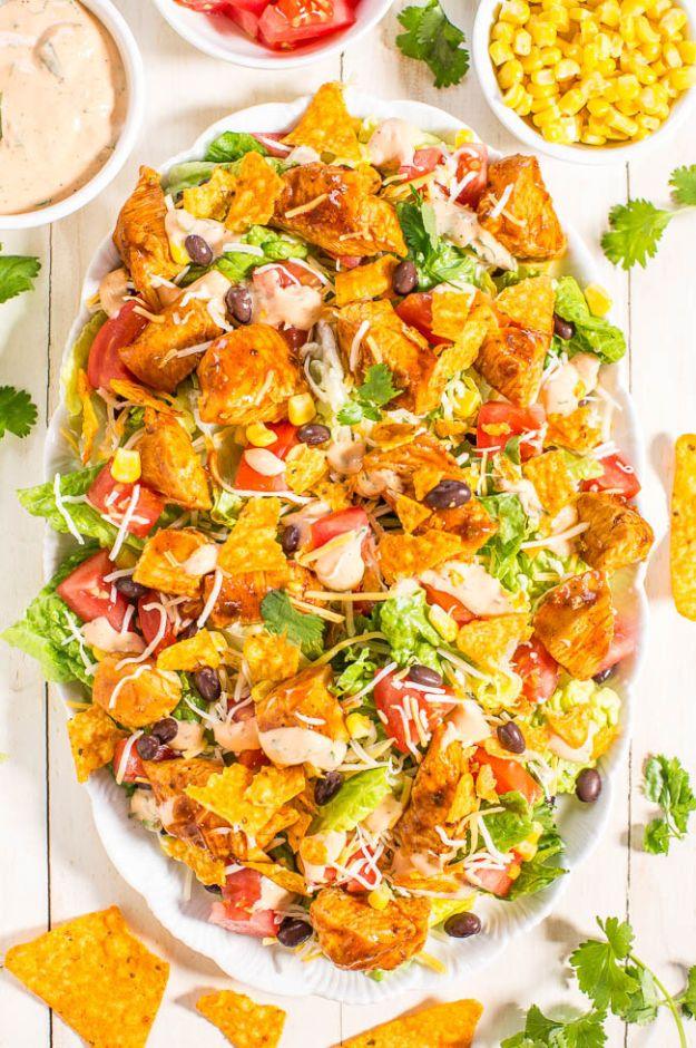 Loaded chicken taco salad with Doritos, romaine, black beans, corn and tomatoes under creamy lime dressing