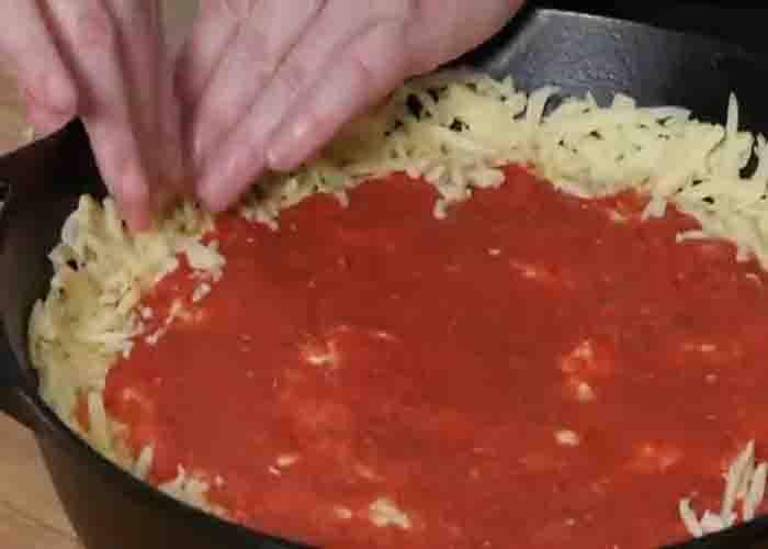 Assembling the pizza onto the cast-iron pan
