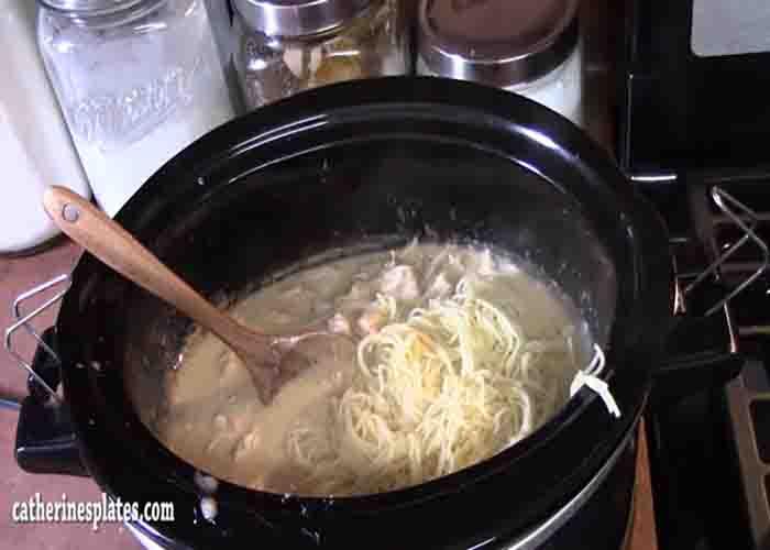 Stirring in the angel pasta into the chicken mixture
