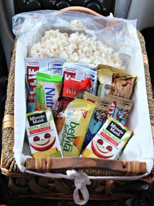 Favorite snack basket for the car, a cloth lined wicker basket of granola bars, popcorn and juice bottles