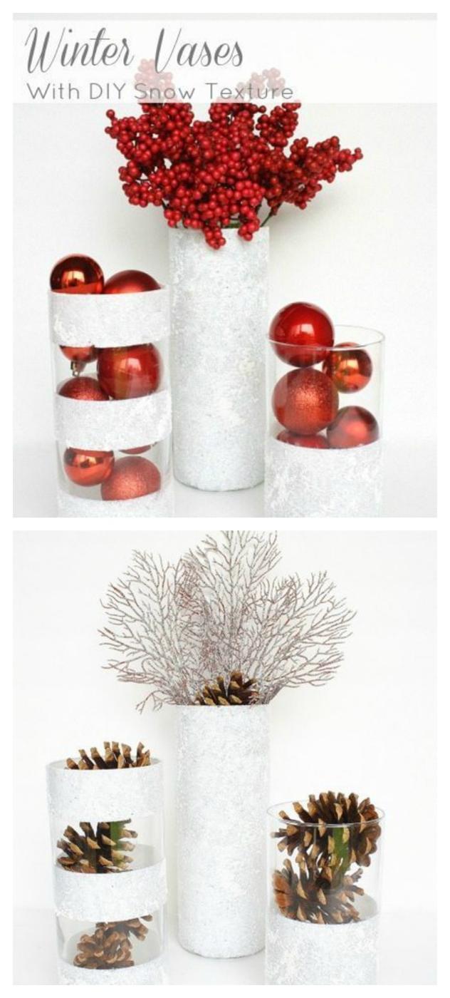 Three glass vases coated with white snow texture paint, one striped, filled with red ornaments and red berry stems