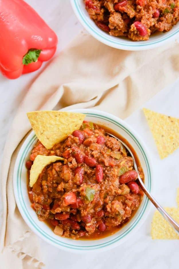 Instant Pot chili with ground beef, kidney beans, zucchini and mushrooms served with guacamole and chips