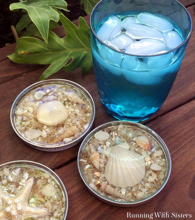 Seashell resin coasters in silver jar lids filled with shell chips and pearls beside a blue iced drink