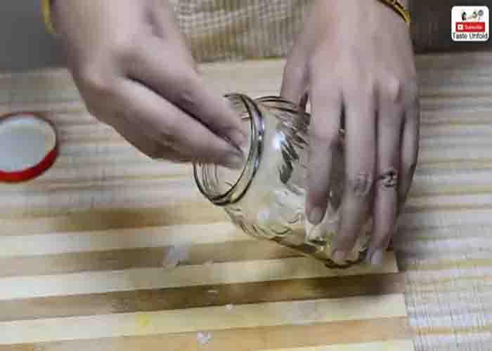 Placing the garlic cloves in the jar, and shaking it to peel the cloves faster