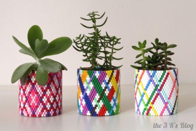 DIY perler bead planter, three succulents in plastic pots wrapped in woven bead sleeves in pink and multicolor