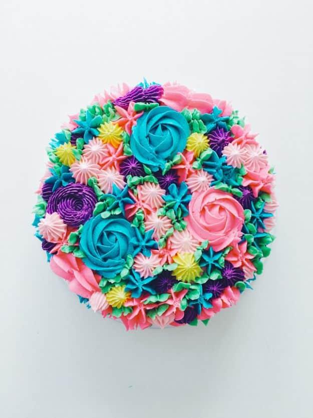Birthday cake topped with a piped rainbow buttercream flower garden in stars, rosettes and leaves recipe for a celebration