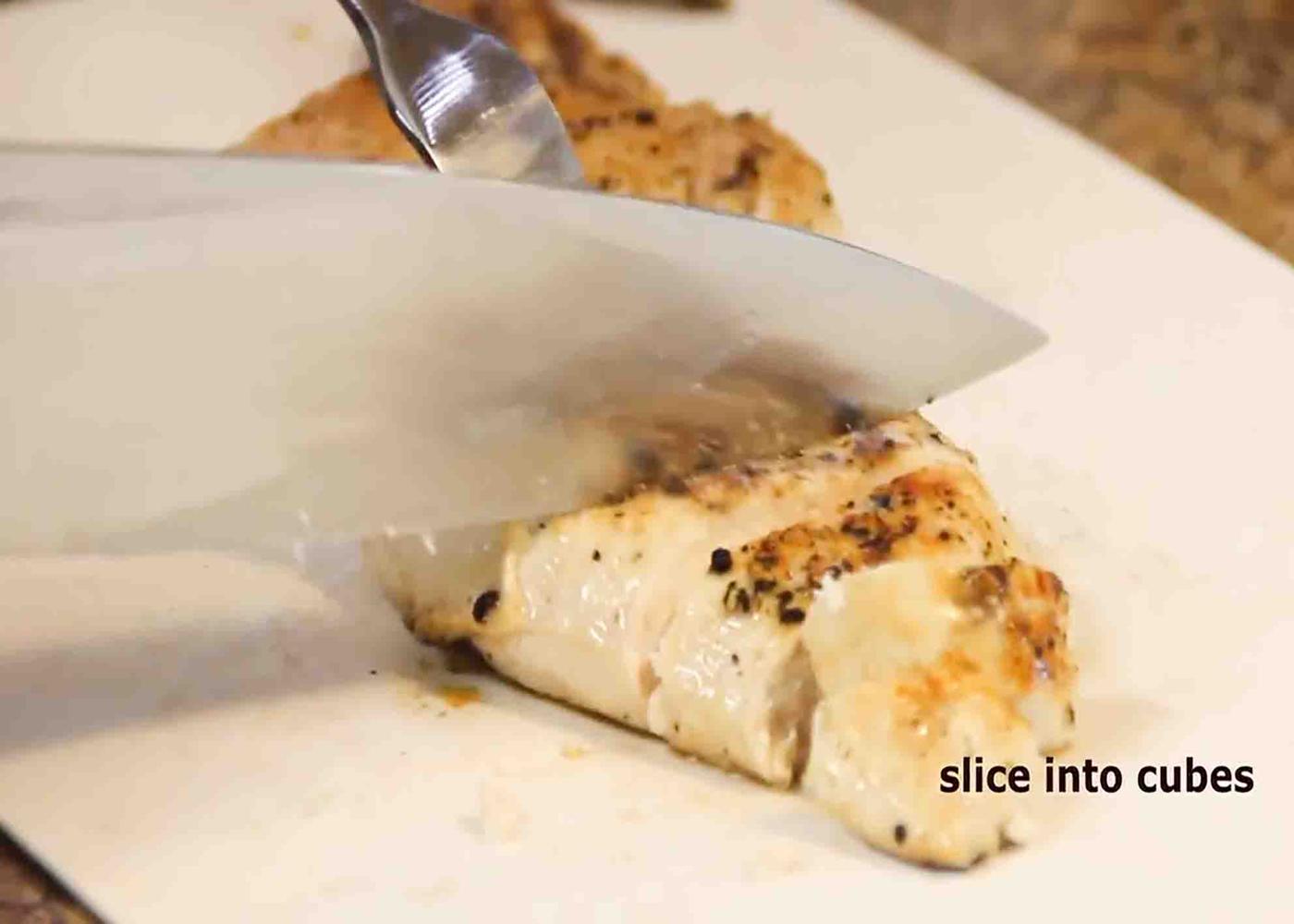Cutting the chicken into bite-size pieces