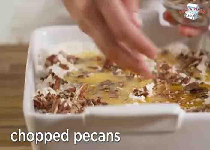 Adding the chopped pecans over the apple pecan dump cake