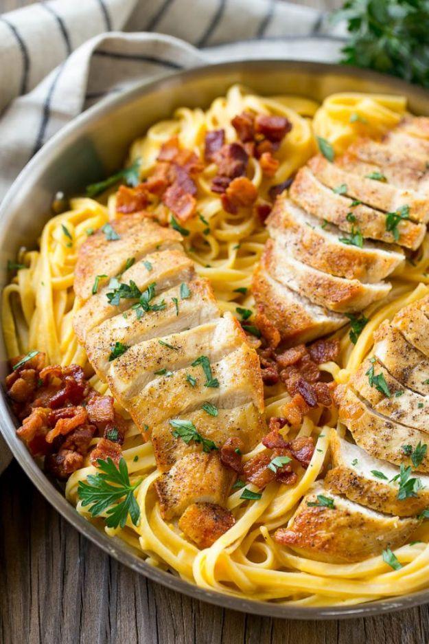 Butternut squash pasta with sliced chicken, bacon and parsley in a large skillet over golden spaghetti