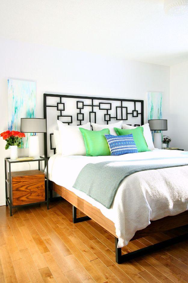 Walnut plywood bed frame with a dark geometric metal headboard and welded steel legs in a bright bedroom