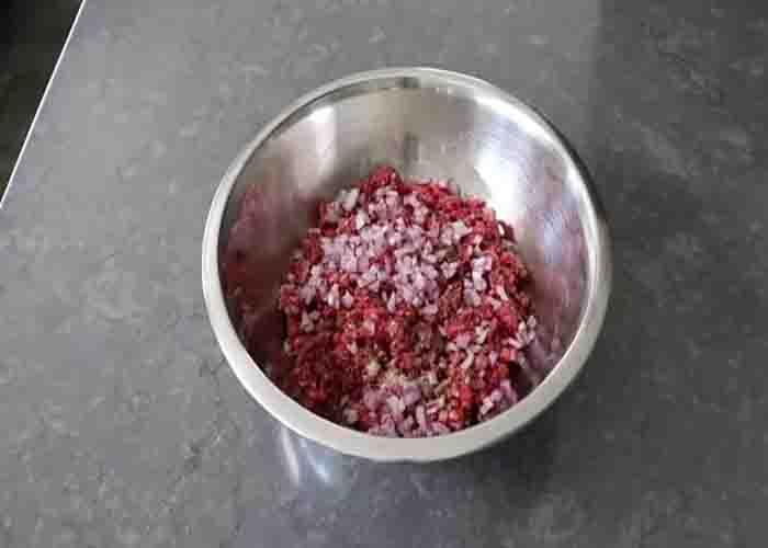 Seasoning the ground beef for the baked burger dogs