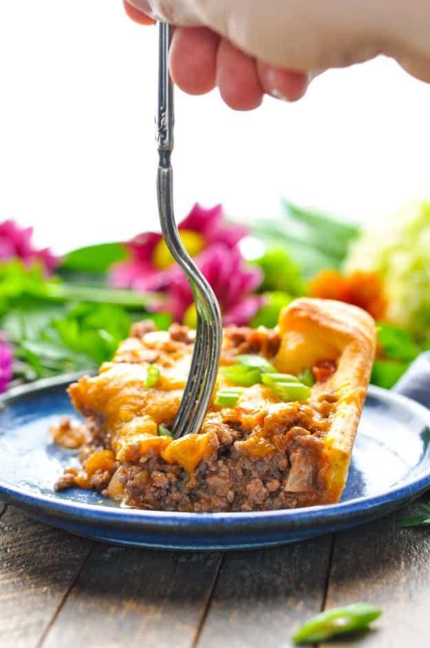 Four ingredient crescent roll ground beef casserole with a golden baked crust and melted cheddar over the top