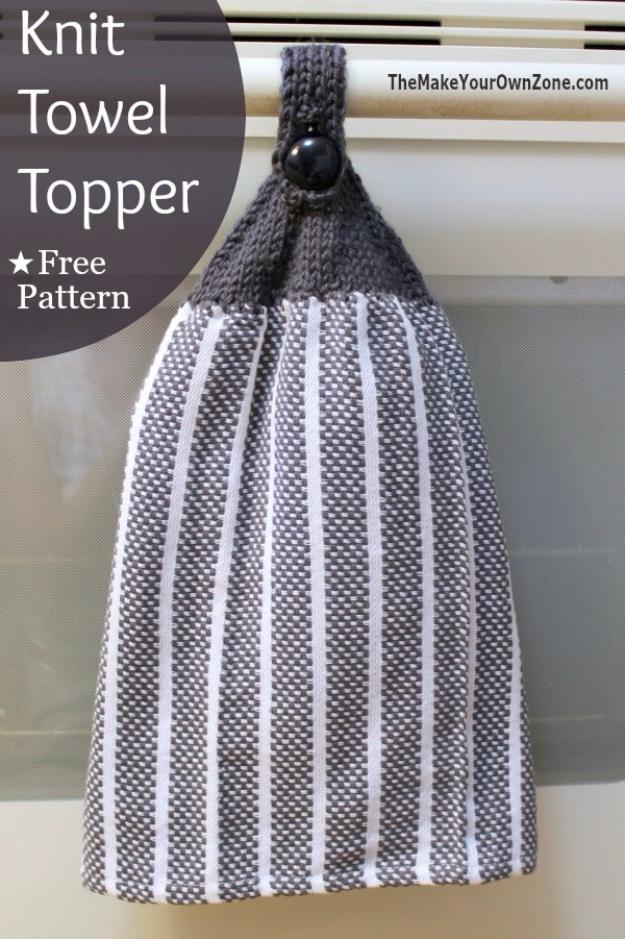 Grey and white striped dish towel with a knitted grey top and a black button hanging from an oven door handle