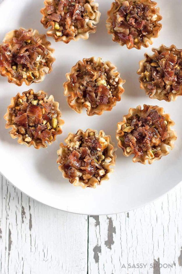 Bacon goat cheese pistachio bites, phyllo cups filled with bacon and chopped pistachios on a white plate