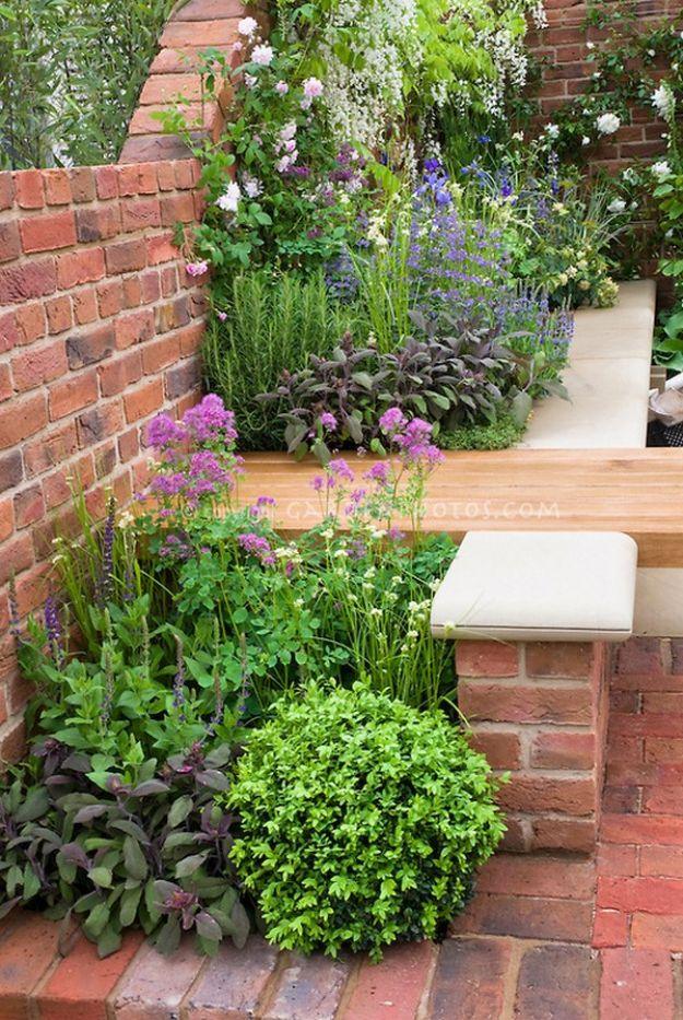 Low weathered brick garden wall curving around a planted bed of lavender, hostas and clipped green shrubs