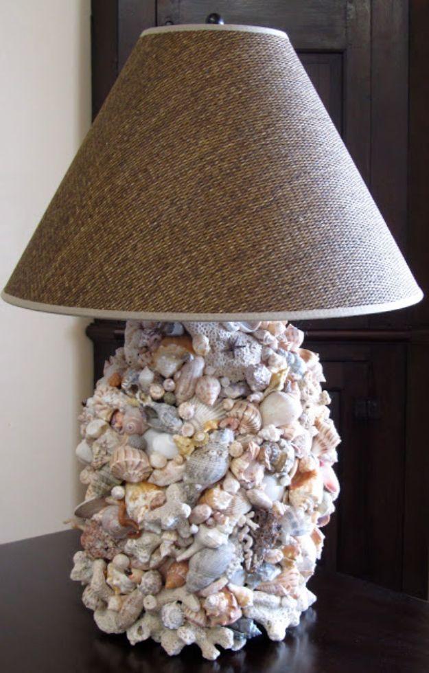 DIY shell lamp, a lamp base covered completely in pale shells and coral, standing under a woven burlap shade