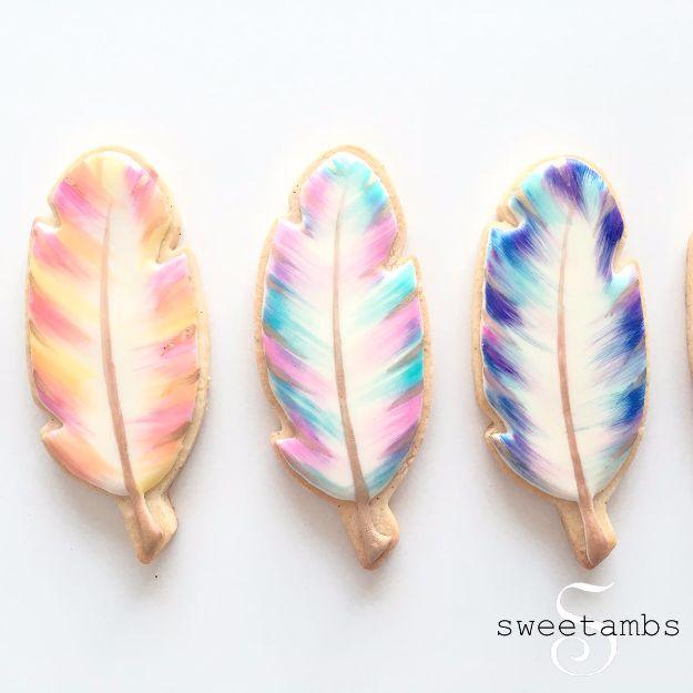 Watercolor feather cookies painted in soft blended colors over white royal icing, finished with pearl dust