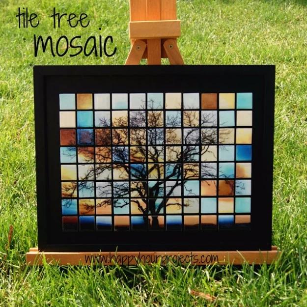 Tile tree mosaic, a framed grid of glass tiles forming a sepia and blue tree image, displayed on a wooden easel on grass