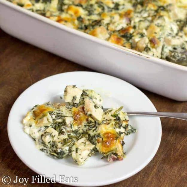Creamy chicken and spinach casserole with bacon served on a white plate beside the full baking dish behind