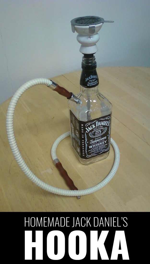 Homemade Jack Daniels hookah built from a whiskey bottle with a ceramic bowl and a long white hose on a table