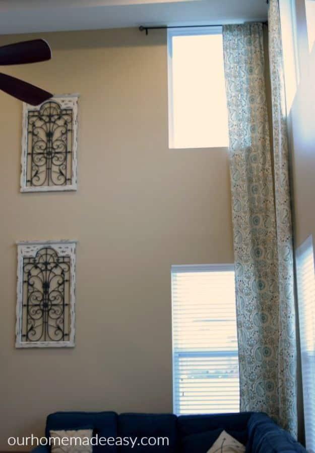 Easy DIY two story curtain panels, a tall patterned panel hanging beside stacked windows on a two story living room wall