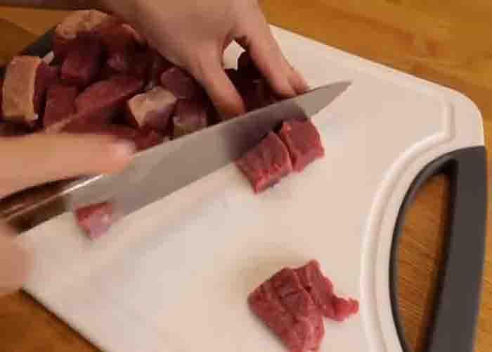Chopping the beef chuck in small pieces for the stew recipe
