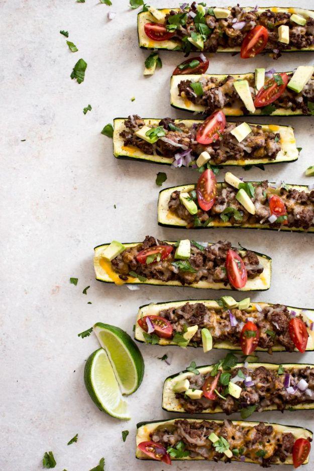 Taco zucchini boats filled with seasoned ground beef, melted Mexican cheese, tomato, cilantro and avocado