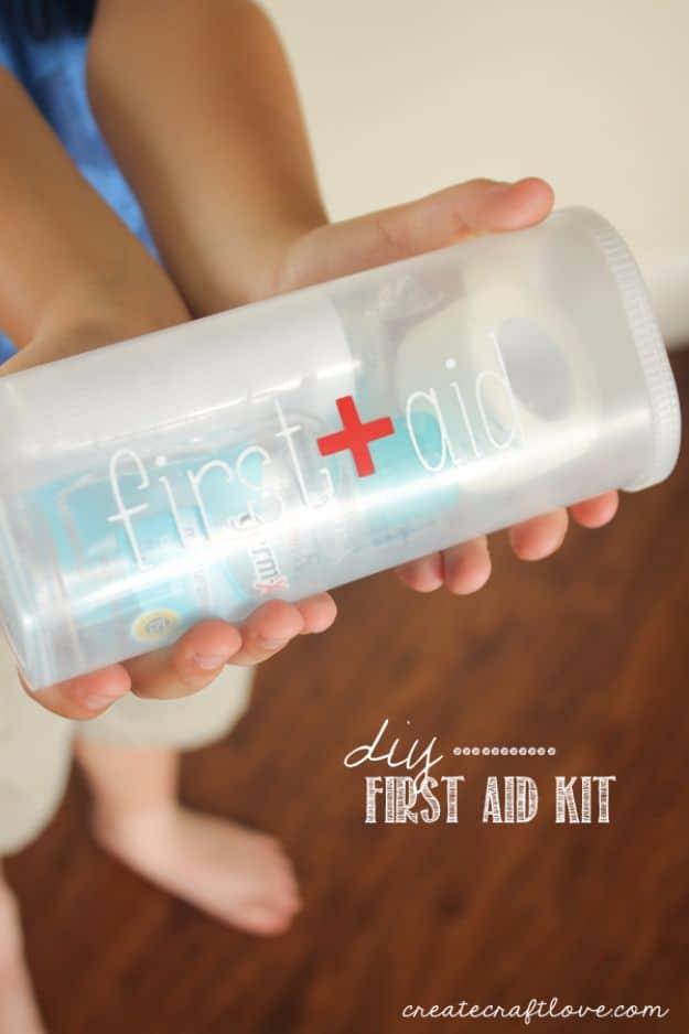 DIY first aid kit made from a clear drink mix canister labeled first aid in blue vinyl, held by a child