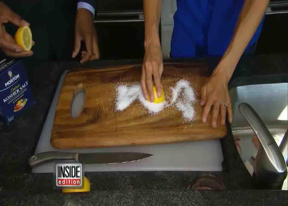 Cleaning the chopping board with salt and lemon
