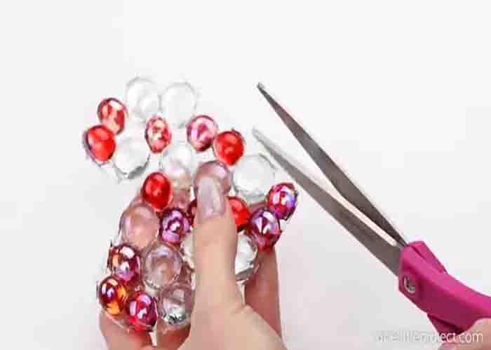Cutting the excess glue on the edges of the heart suncatcher