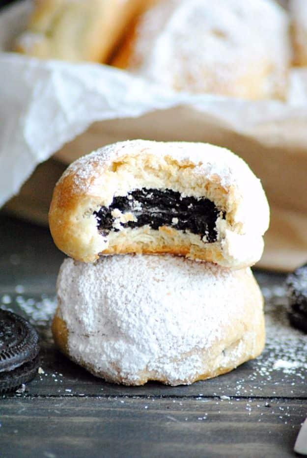 Baked deep fried Oreos wrapped in crescent roll dough and dusted with powdered sugar on a baking sheet