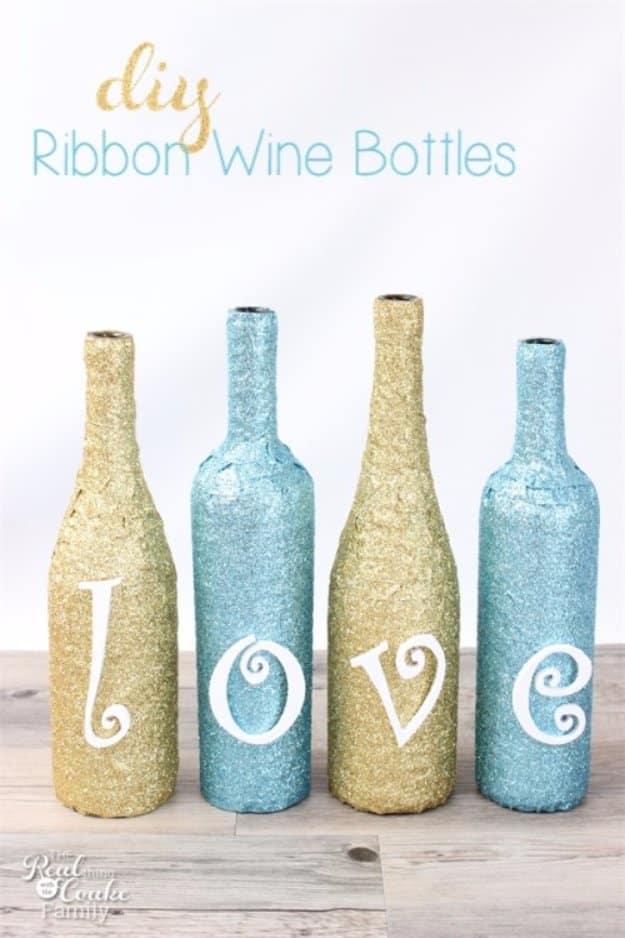 Glittery ribbon wine bottles, four bottles wrapped in gold and blue glitter ribbon spelling the word love