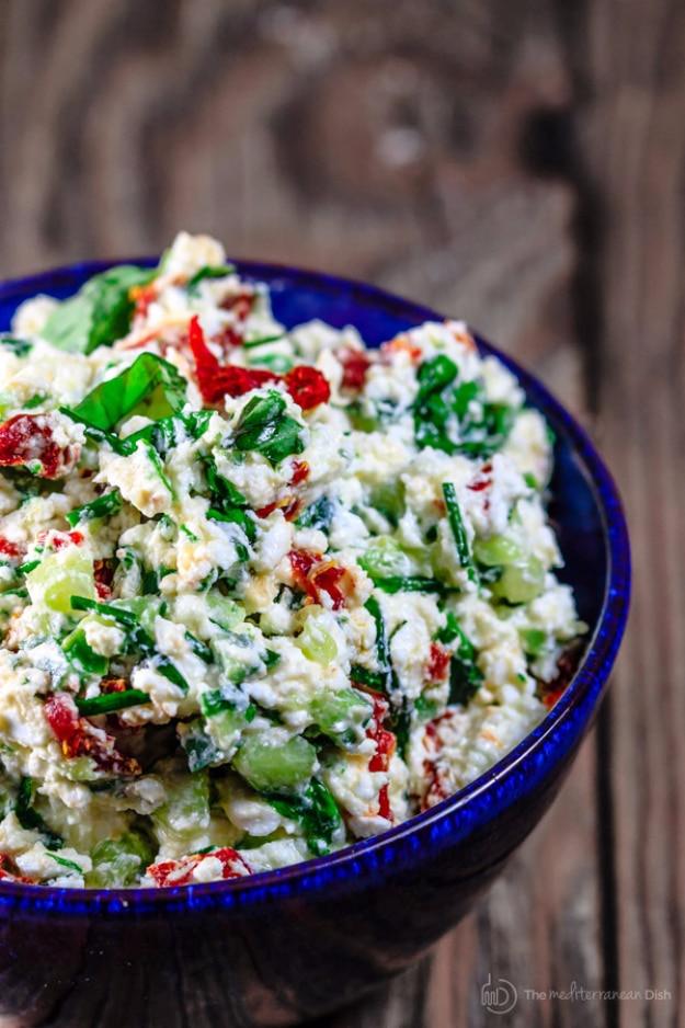 Last minute Mediterranean feta cheese dip with cucumber, sun dried tomatoes and fresh basil in a serving bowl