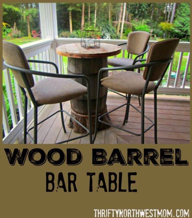 Wood barrel bar table on a deck, a round wooden top on an oak barrel with four tall patio chairs around it