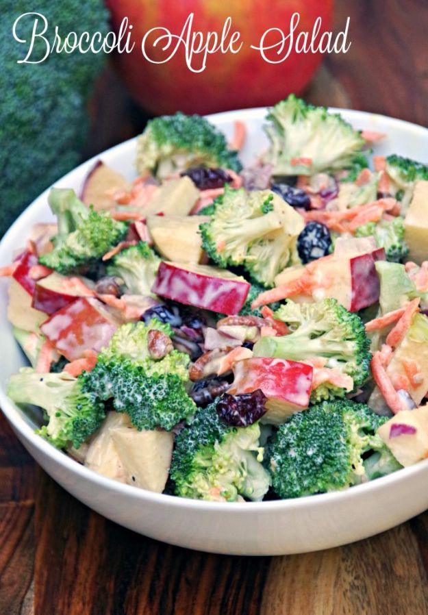 Creamy broccoli apple salad with broccoli florets, apple chunks and cranberries in white dressing in a white bowl