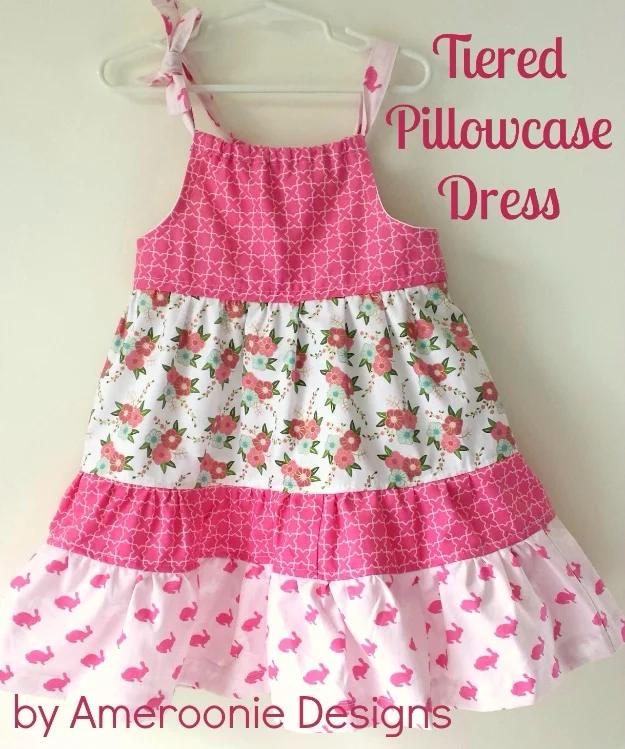 Three tier pillowcase dress in pink quatrefoil, floral and bunny prints with tie straps, under a typeset title
