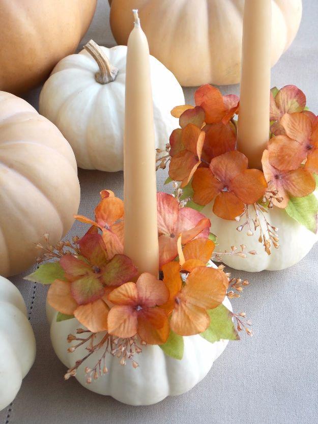 White pumpkins used as taper candle holders with rings of peach and orange silk hydrangea glued around them